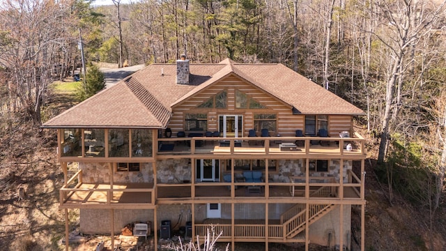449 Lucerne Way, Gatlinburg, TN 37738 - rear view of house featuring a chimney, stone siding, a shingled roof, and a view of trees