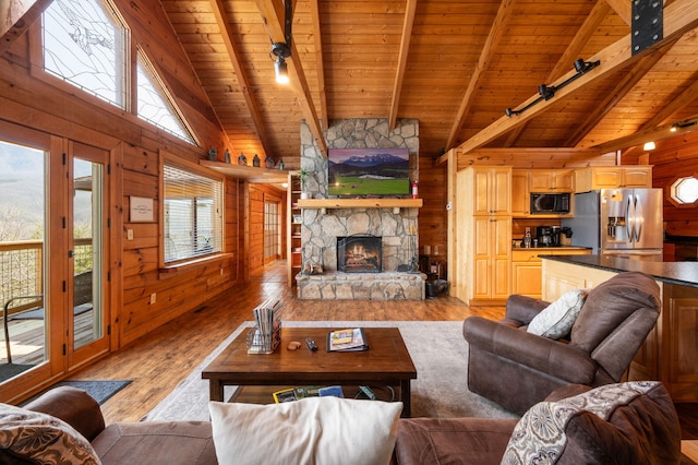 449 Lucerne Way, Gatlinburg, TN 37738 - living room featuring wooden walls, a stone fireplace, wooden ceiling, rail lighting, and light wood finished floors