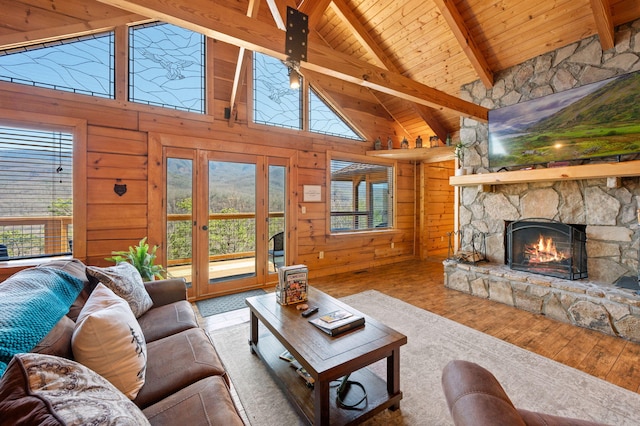 449 Lucerne Way, Gatlinburg, TN 37738 - living room featuring vaulted ceiling with beams, wood walls, wood ceiling, a stone fireplace, and wood finished floors
