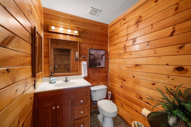 449 Lucerne Way, Gatlinburg, TN 37738 - bathroom with visible vents, wood walls, toilet, tile patterned floors, and vanity