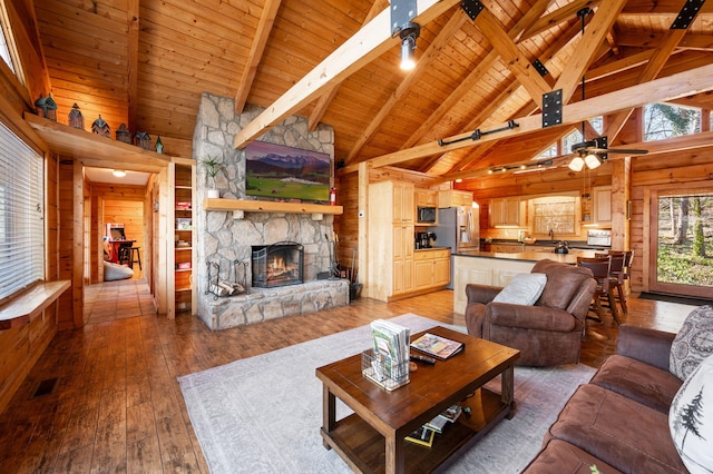 449 Lucerne Way, Gatlinburg, TN 37738 - living room with light wood-type flooring, beam ceiling, wood walls, a fireplace, and wood ceiling