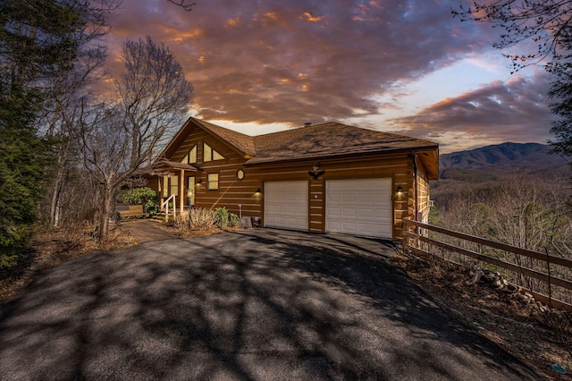 449 Lucerne Way, Gatlinburg, TN 37738 - view of property exterior featuring an attached garage, a shingled roof, fence, driveway, and a mountain view