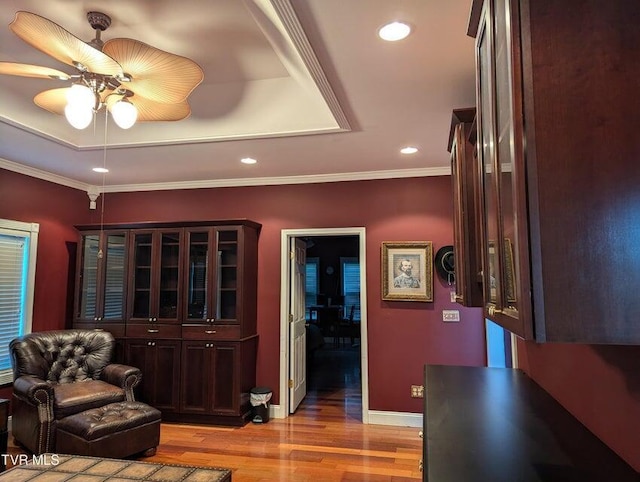 interior space featuring ceiling fan, light hardwood / wood-style floors, and ornamental molding