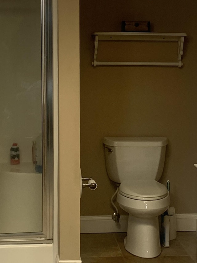 bathroom featuring tile patterned floors, toilet, and walk in shower