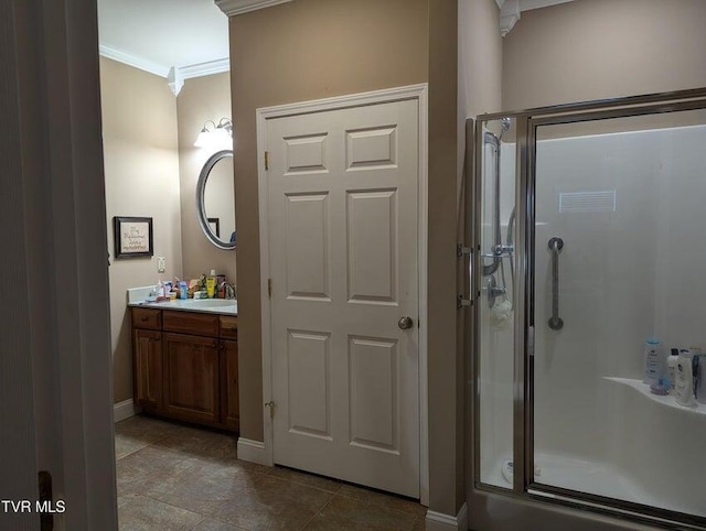 bathroom with vanity, a shower with shower door, and crown molding