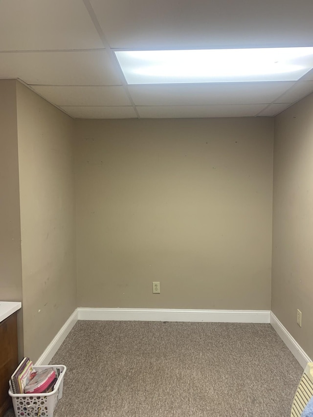 carpeted spare room with a paneled ceiling