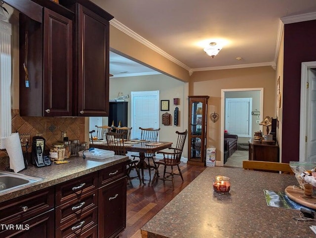 kitchen featuring dark hardwood / wood-style flooring, tasteful backsplash, dark brown cabinetry, crown molding, and sink