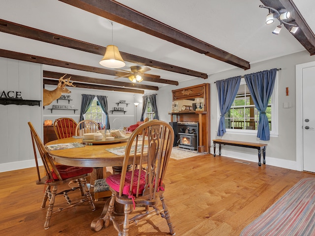 6525 Idumea Rd, Corryton, TN 37721 - dining space featuring baseboards, light wood-style floors, a ceiling fan, beamed ceiling, and a wood stove