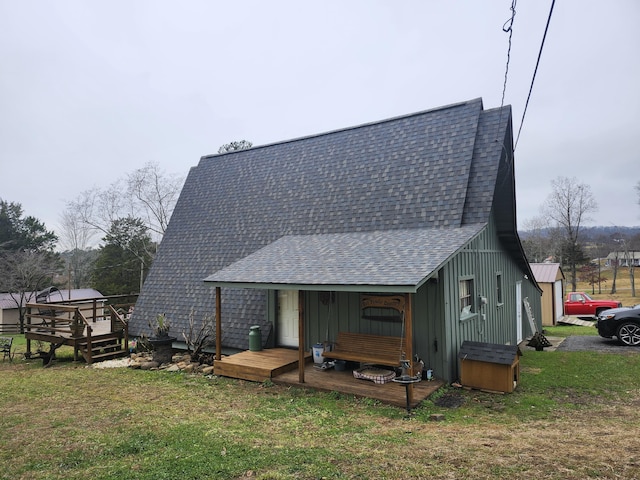 rear view of property featuring a deck and a lawn