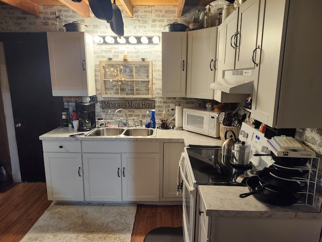 kitchen with brick wall, white cabinetry, wood-type flooring, sink, and range