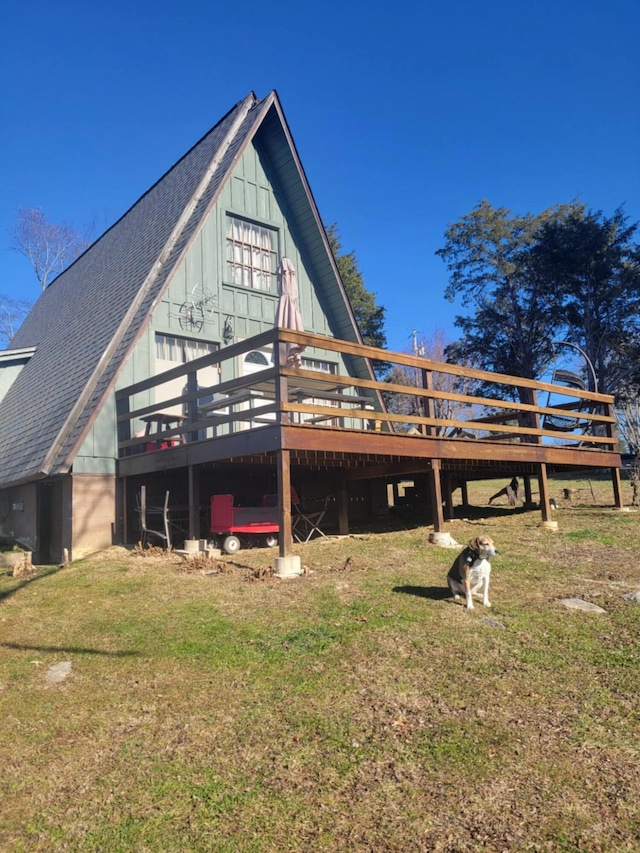 rear view of property with a wooden deck and a yard