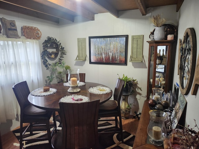 dining area with hardwood / wood-style flooring and beam ceiling