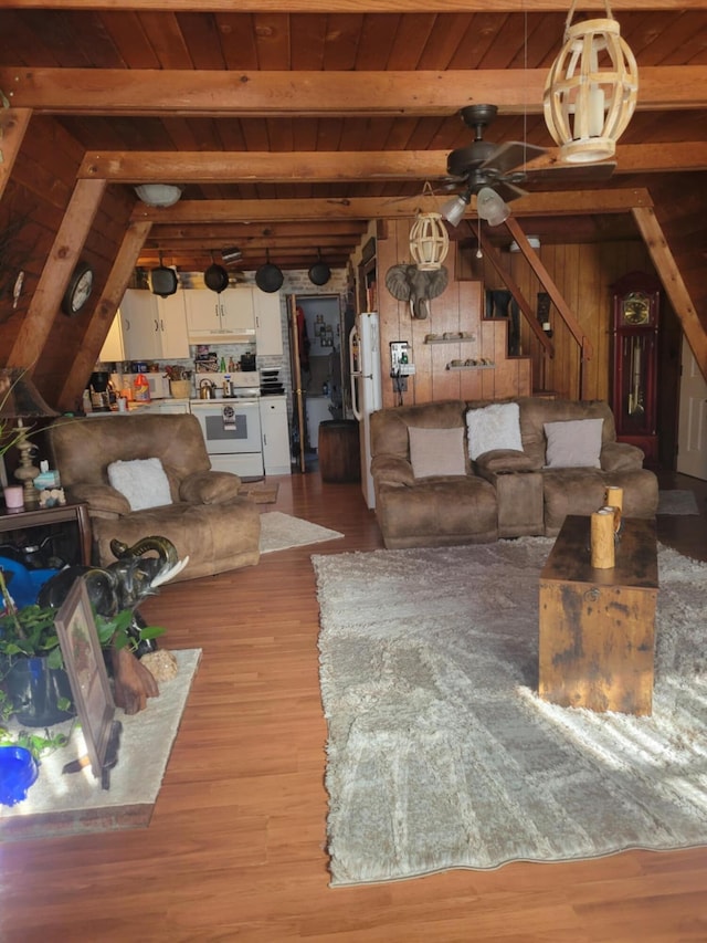 living room with hardwood / wood-style floors, wood walls, ceiling fan, wooden ceiling, and beam ceiling