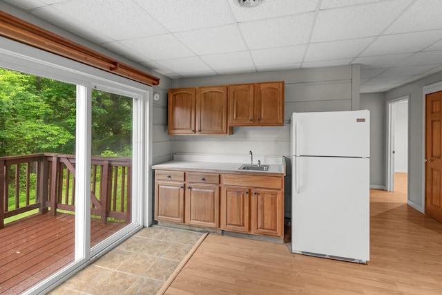 2935 Glendale Community Rd, Greenback, TN 37742 - kitchen with freestanding refrigerator, a sink, light wood finished floors, light countertops, and brown cabinetry