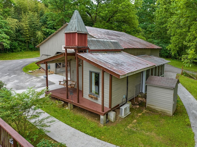 2935 Glendale Community Rd, Greenback, TN 37742 - view of property exterior with a deck, metal roof, ac unit, a detached garage, and a forest view