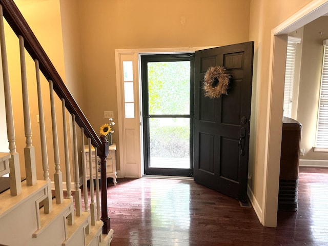 entrance foyer with dark wood-style floors, baseboards, and stairway