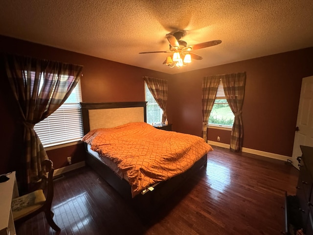 bedroom featuring ceiling fan, a textured ceiling, baseboards, and hardwood / wood-style floors