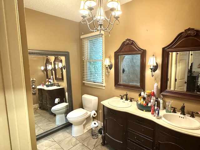 full bathroom featuring double vanity, a sink, toilet, and an inviting chandelier