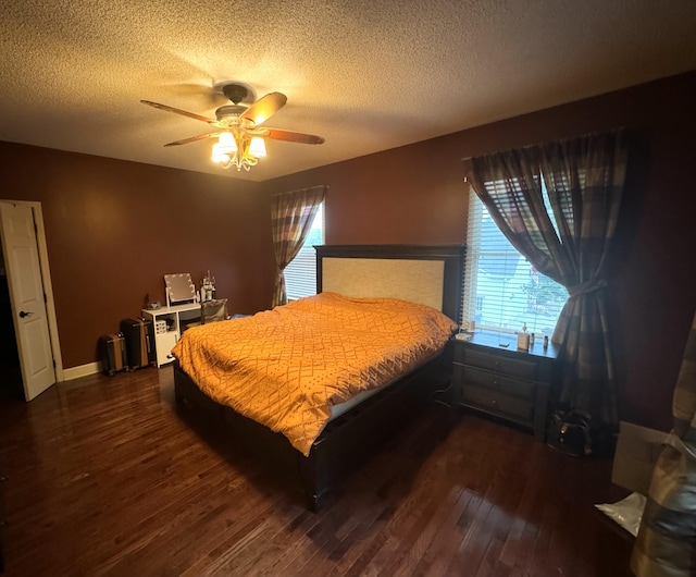 bedroom with a textured ceiling, dark wood finished floors, a ceiling fan, and baseboards