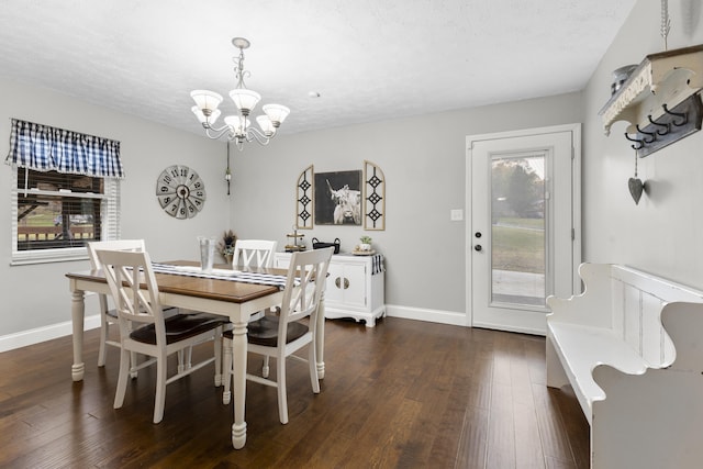 dining space with a chandelier, dark wood-type flooring, and a textured ceiling