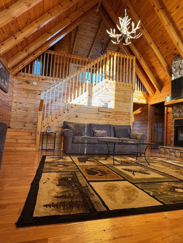 unfurnished living room featuring wooden ceiling, beamed ceiling, wooden walls, and a stone fireplace