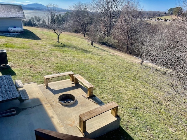 view of yard with an outdoor fire pit, a patio area, cooling unit, and a mountain view