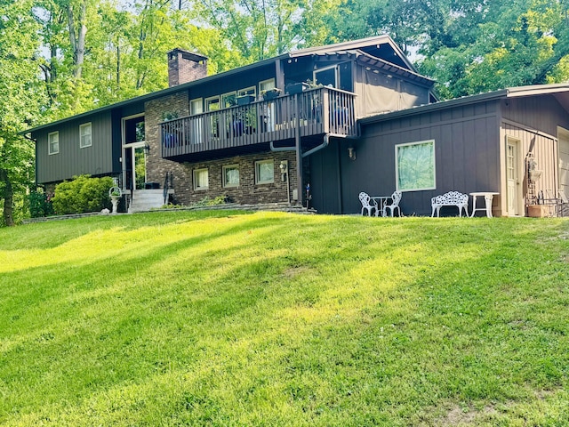 rear view of house with a lawn, a deck, and a chimney