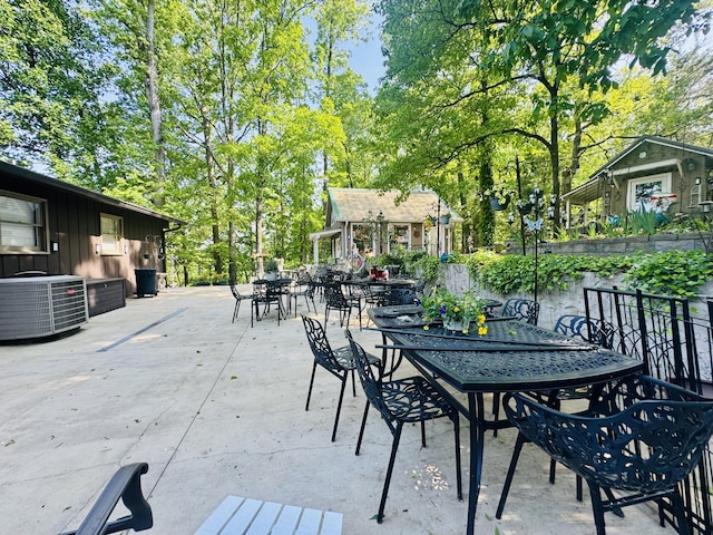 view of patio featuring central air condition unit, an outdoor structure, and outdoor dining area