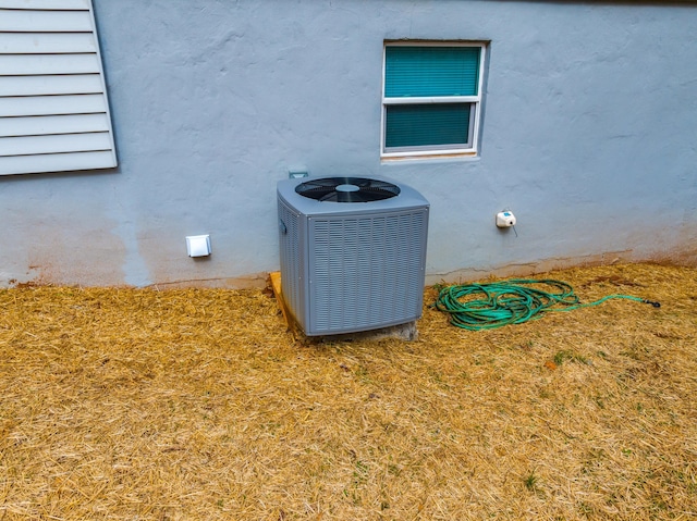 exterior details featuring central AC and stucco siding