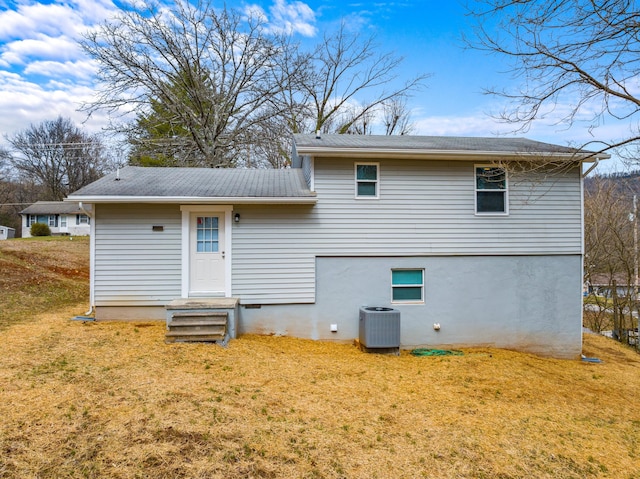 back of property featuring a yard and central air condition unit