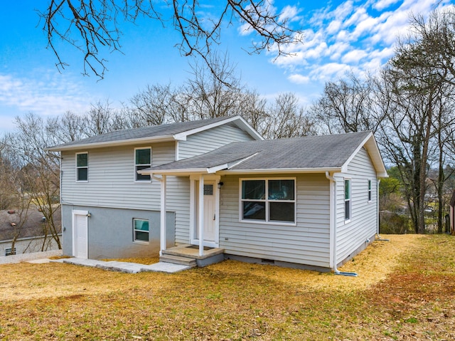 split level home with a front yard, a garage, and roof with shingles