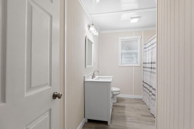 full bathroom with toilet, wood finished floors, crown molding, baseboards, and vanity