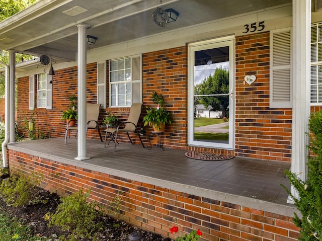 view of exterior entry featuring covered porch