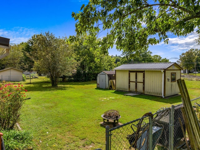 view of yard with a storage unit and a fire pit