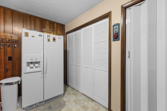 kitchen with white fridge with ice dispenser and a textured ceiling