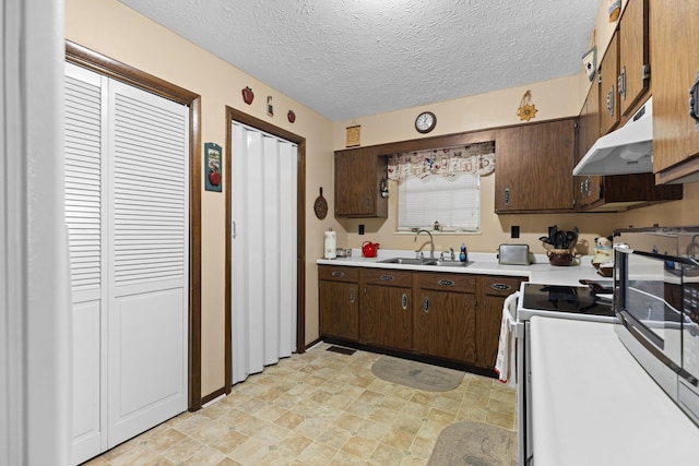 kitchen with dark brown cabinets, sink, a textured ceiling, and white range with electric stovetop