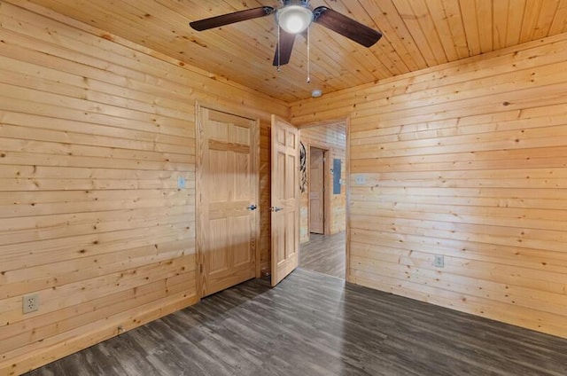 empty room with wooden walls, ceiling fan, wood ceiling, and dark hardwood / wood-style floors