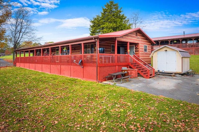 view of front of property with a front lawn and a storage shed