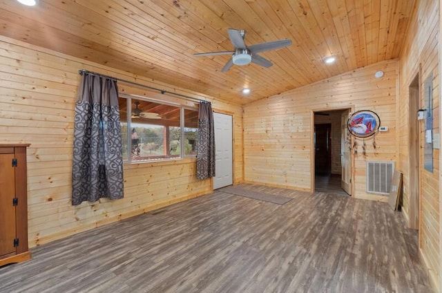 spare room with wood walls, dark wood-type flooring, vaulted ceiling, ceiling fan, and wood ceiling