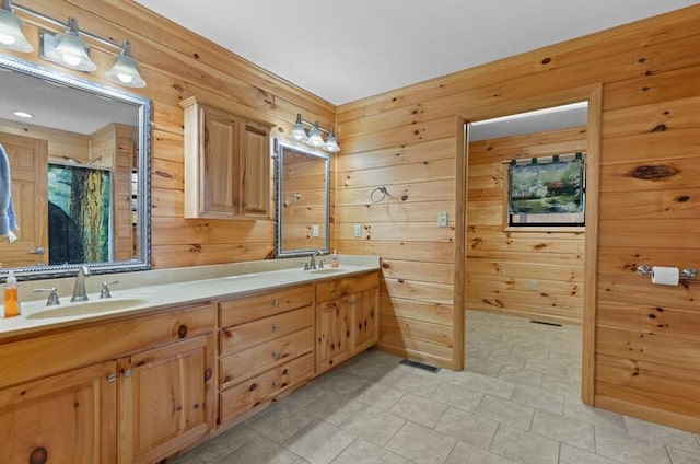 bathroom featuring vanity, a shower, and wooden walls