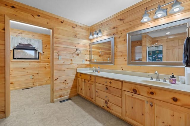 bathroom featuring tile patterned floors, wooden walls, and vanity