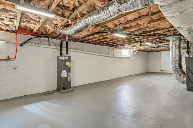 unfinished basement featuring water heater and concrete block wall
