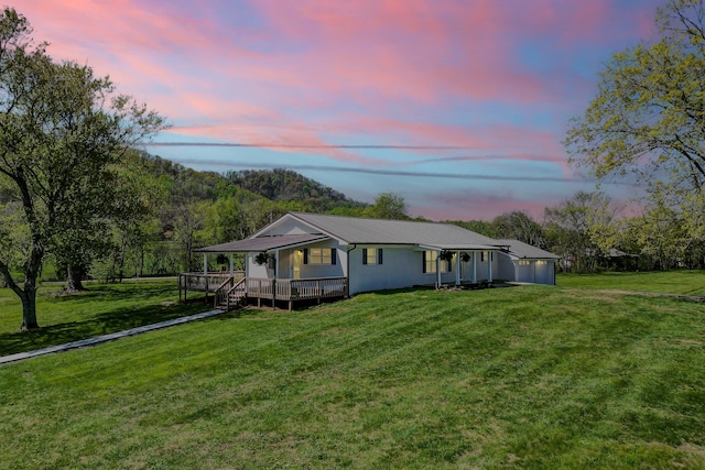 view of front of property with a wooden deck and a front yard