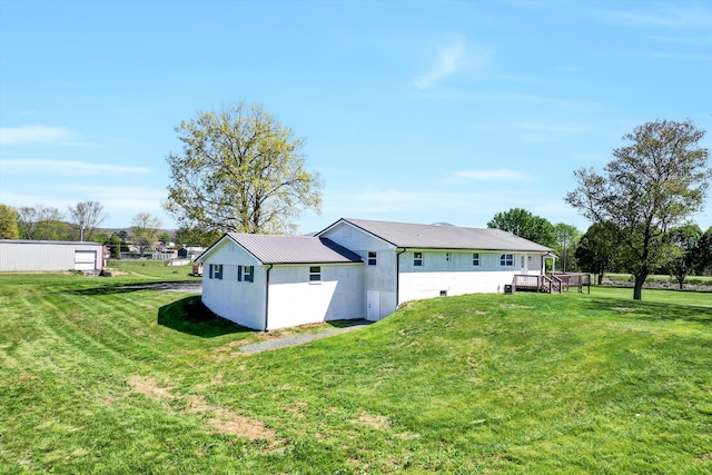 back of property with a yard and metal roof