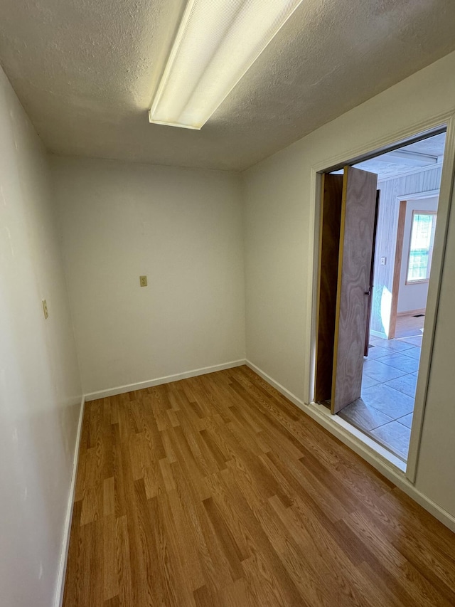 empty room featuring wood-type flooring and a textured ceiling