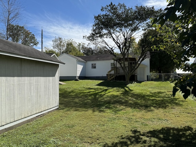 view of yard with a wooden deck and a storage shed