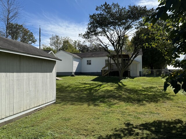 view of yard with a wooden deck and a storage shed