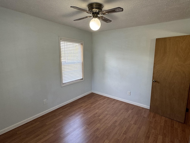 empty room with dark hardwood / wood-style floors, ceiling fan, and a textured ceiling