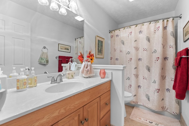 bathroom with tile patterned floors, vanity, a textured ceiling, toilet, and curtained shower