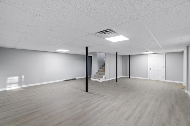 basement with hardwood / wood-style flooring and a paneled ceiling